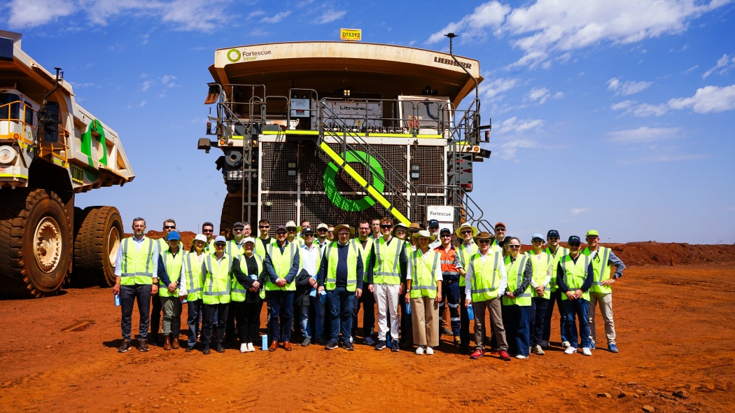 Die Delegation und ein Team von der australischen Firma Fortescue vor einem Prototypen eines wasserstoffangetriebenen Muldenkippers in der Christmas Creek Eisenerz-Mine. Copyright: Fortescue