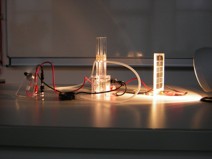 Versuchsaufbau: Stromerzeugung mit Hilfe eines Solarmoduls; Erzeugung von Wasserstoff durch Elektrolyse sowie Umwandlung des Wasserstoffs in elektrische Energie durch eine Brennstoffzelle und Verbraucher.