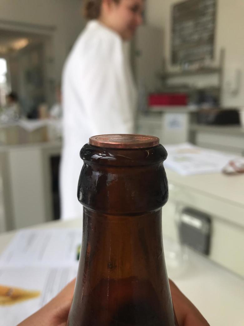 Münze auf Öffnung einer kalten Glasflasche